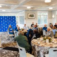 Photo of room and event guests listening to Don Lubbers speaking
